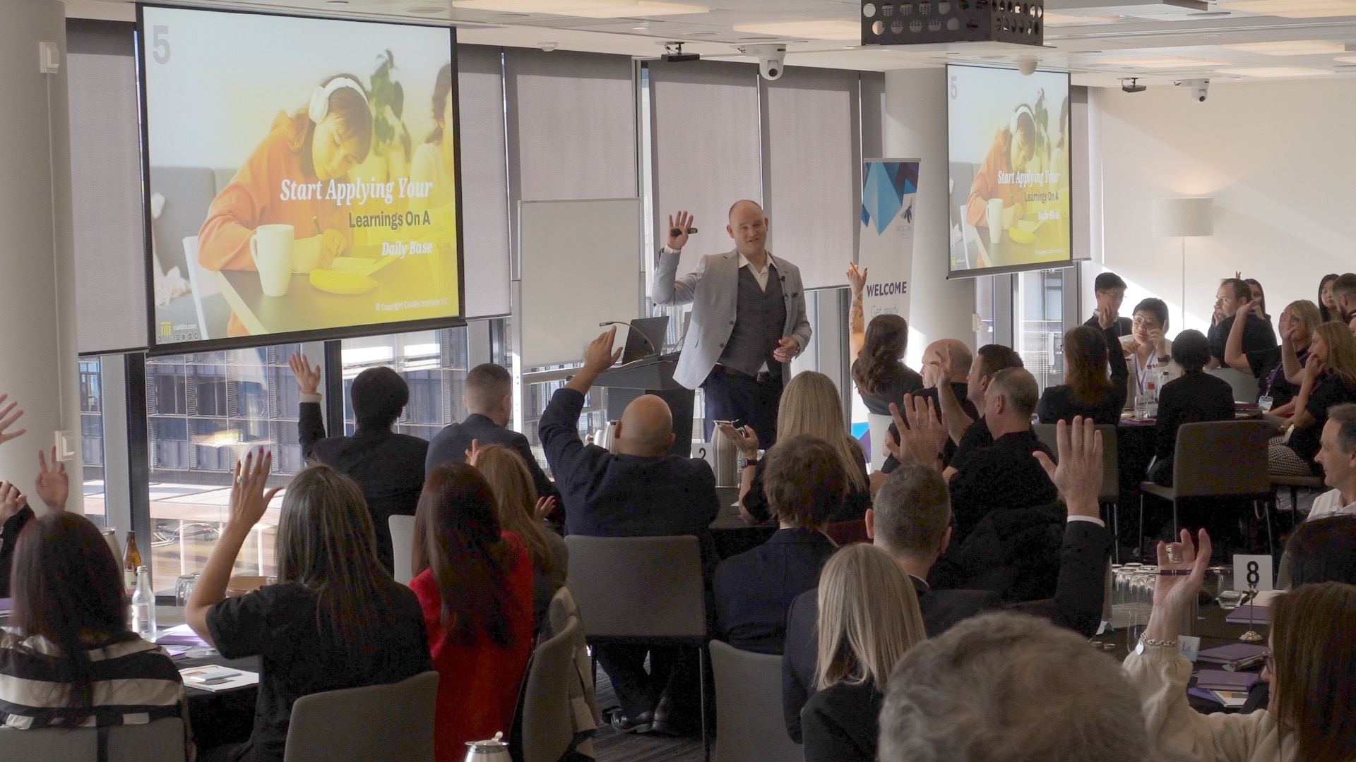 Patrick speaking at the PROLOAN presentation with hand raised at the start