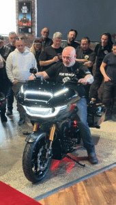 Motorcycle riders gather as a custom Harley Davidson is revealed and started